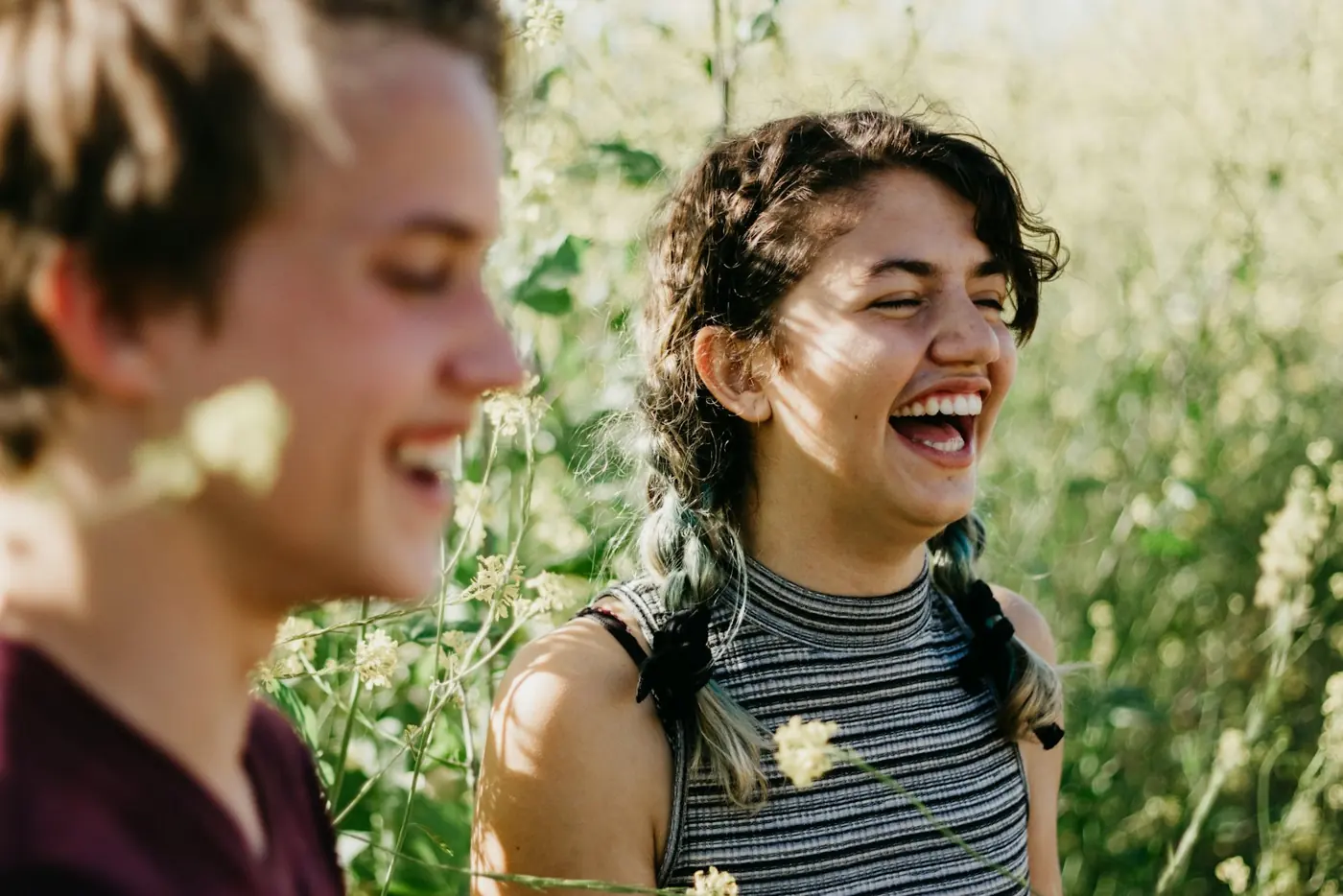 Two friends laughing in tall grass